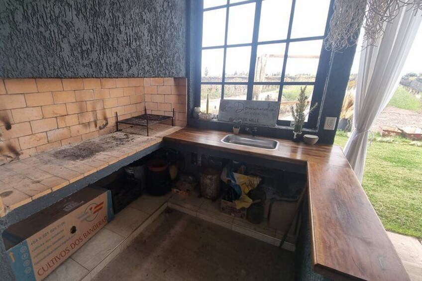 A kitchen with a brick backsplash, a window with a view, and a sign on the counter. 5