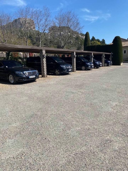 A parking area with several cars parked under a covered structure. 2