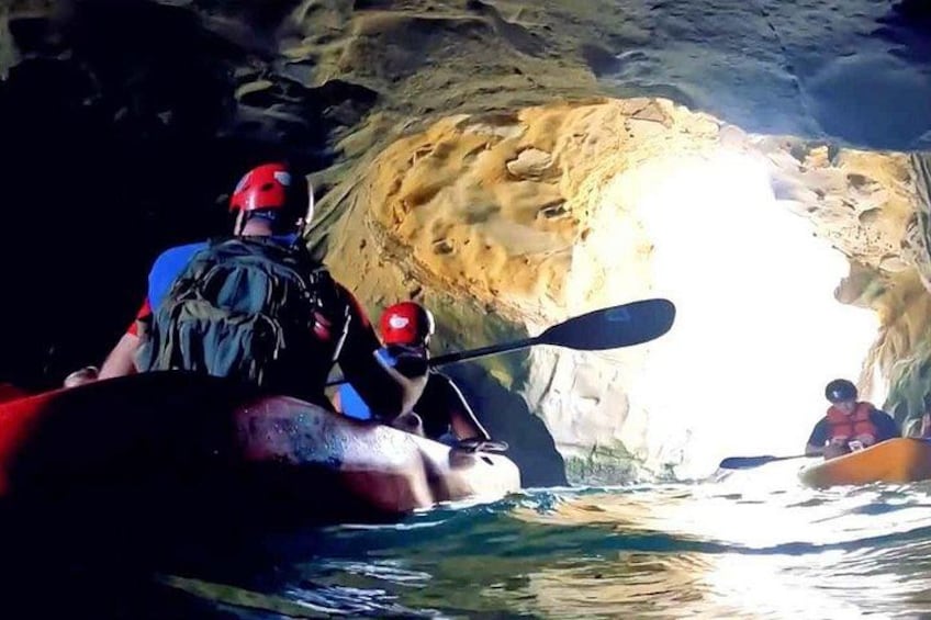 A person kayaking through a cave with a rocky interior. 3