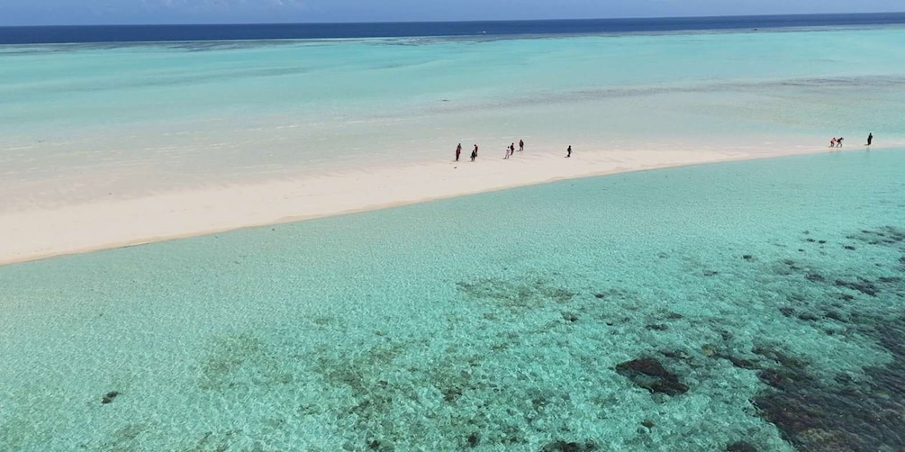 A beach with clear turquoise water and a sandy shore. 1
