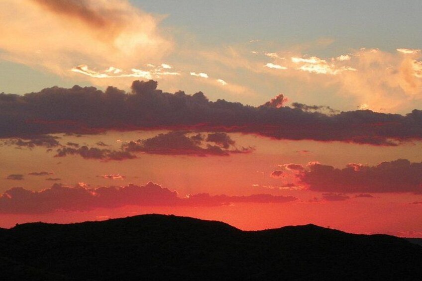 Un coucher de soleil sur un paysage montagneux, avec des nuages. 1