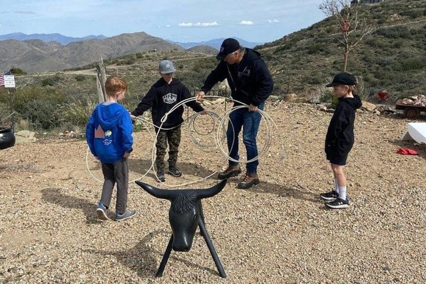 Un groupe de personnes joue avec des cerceaux de hula dans un paysage désertique, avec des montagnes en arrière-plan. 4