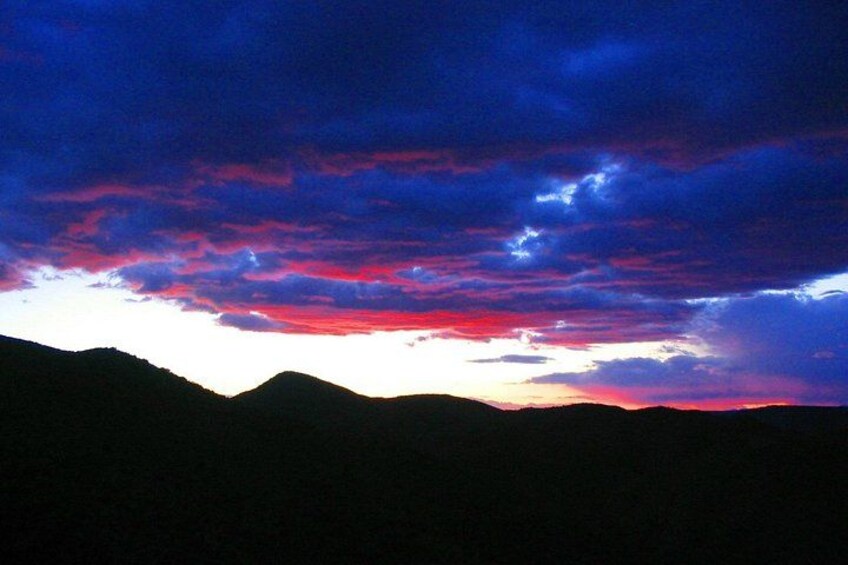 Un coucher de soleil sur une chaîne de montagnes, avec un ciel aux couleurs vives. 3