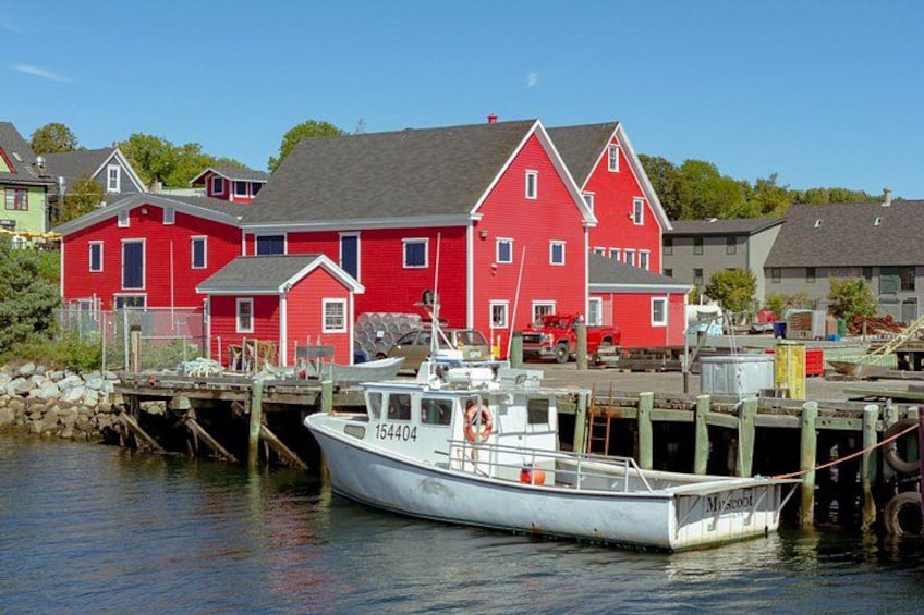 Ein rotes Haus, ein weißes Boot und eine Anlegestelle. 2
