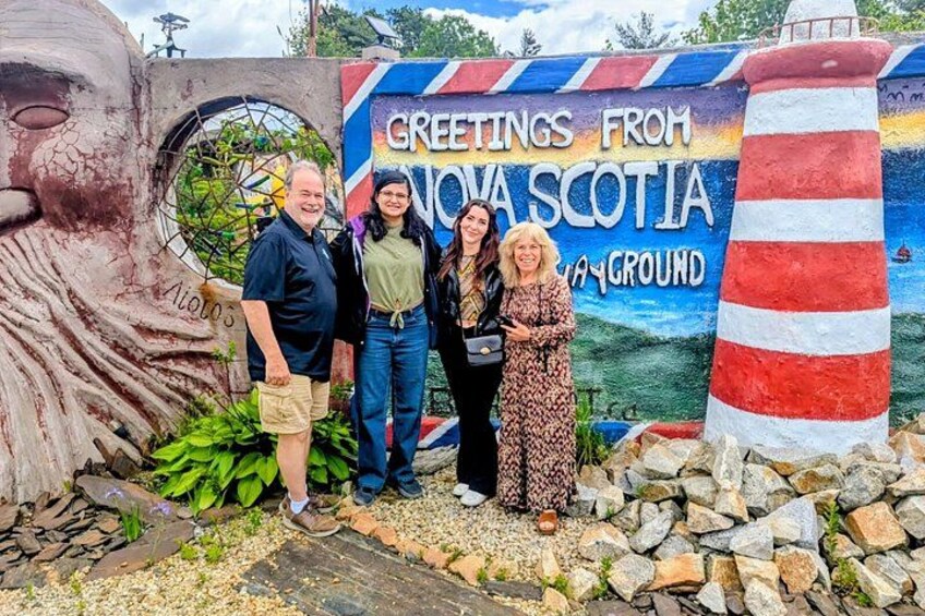 Ein Wandgemälde zeigt einen Leuchtturm und ein Gesicht, sowie ein Schild mit der Aufschrift 'Greetings from Nova Scotia'. 1
