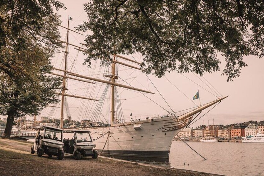 Un gran barco de vela amarrado cerca de un muelle, con un paisaje urbano al fondo. 5