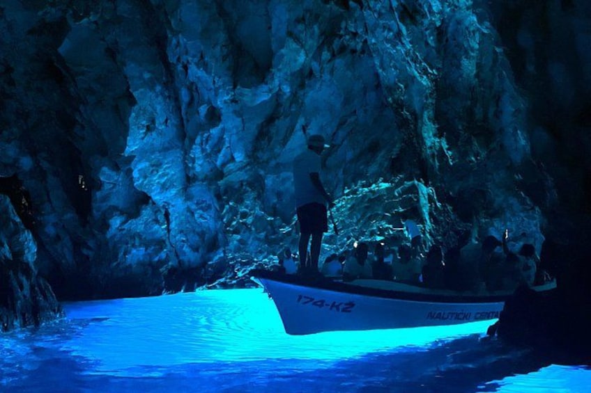 A boat named 'Nautical Explorer' on a blue-lit water body with rocky surroundings. 1
