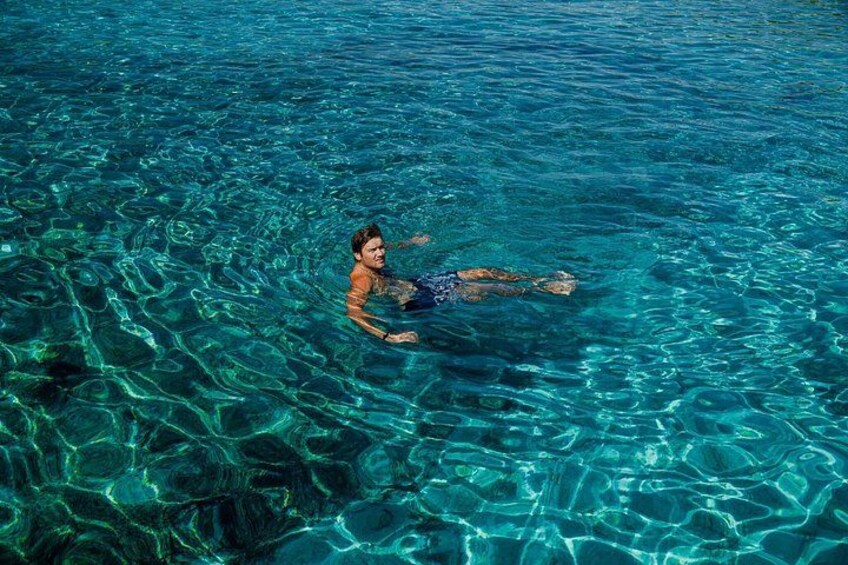 A person swimming in clear blue water. 2