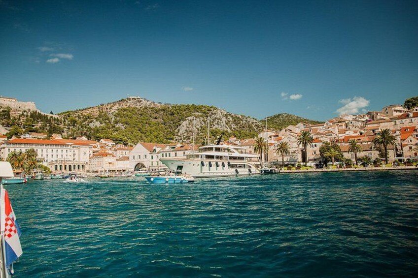 A coastal town with a prominent white boat docked near a pier, surrounded by buildings and hills. 5