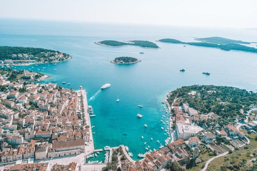 An aerial view of a coastal town with a marina, boats, and surrounding islands. 3