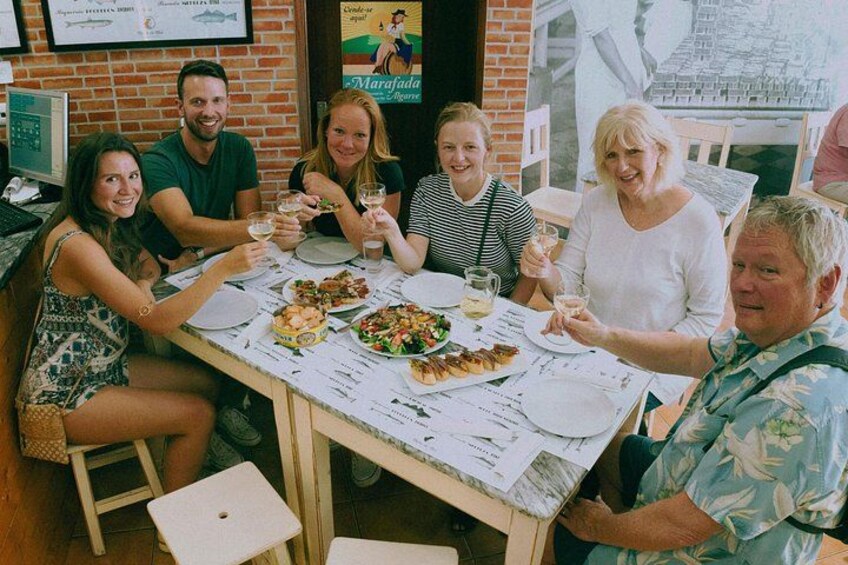 A group of people dining at a restaurant with a menu and a poster on the wall. 4