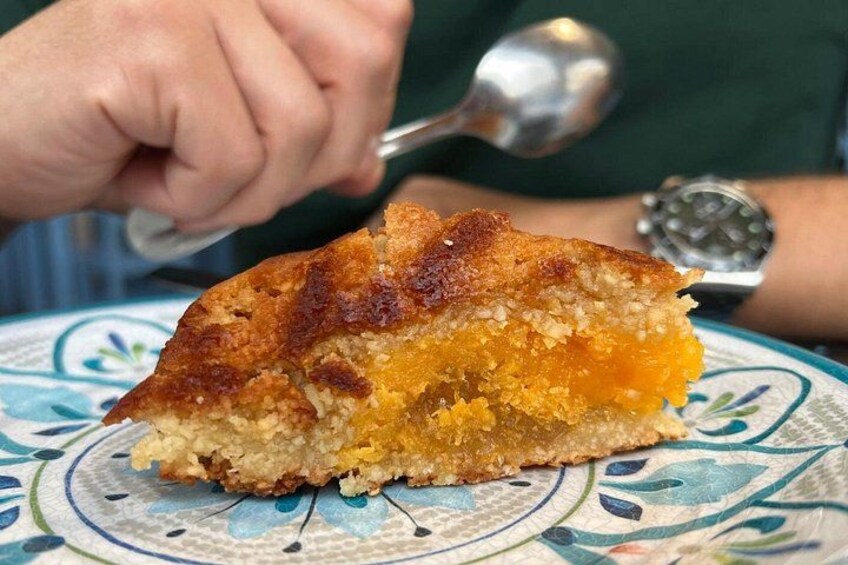 A slice of cake with a golden-brown crust on a patterned plate. 2