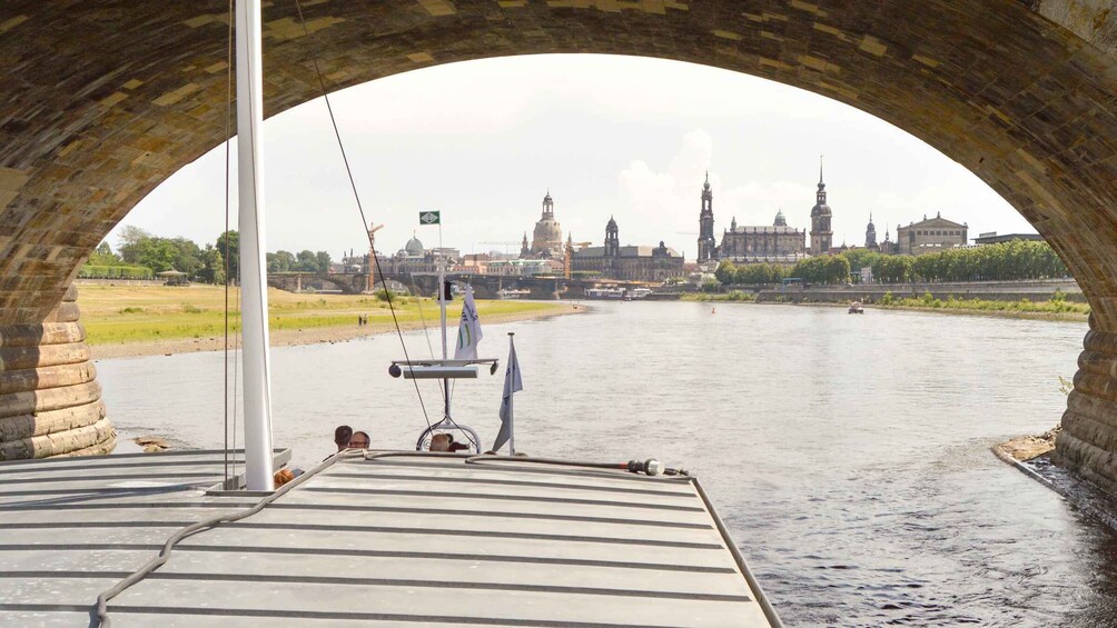 A river with a cityscape in the background, viewed through a stone archway. 2