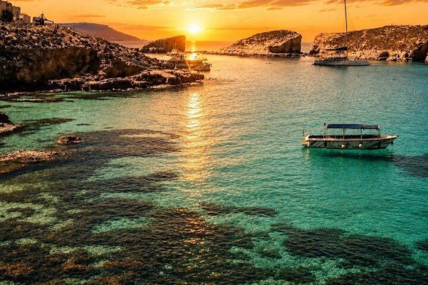 Un barco sobre un mar turquesa con un atardecer al fondo. 3