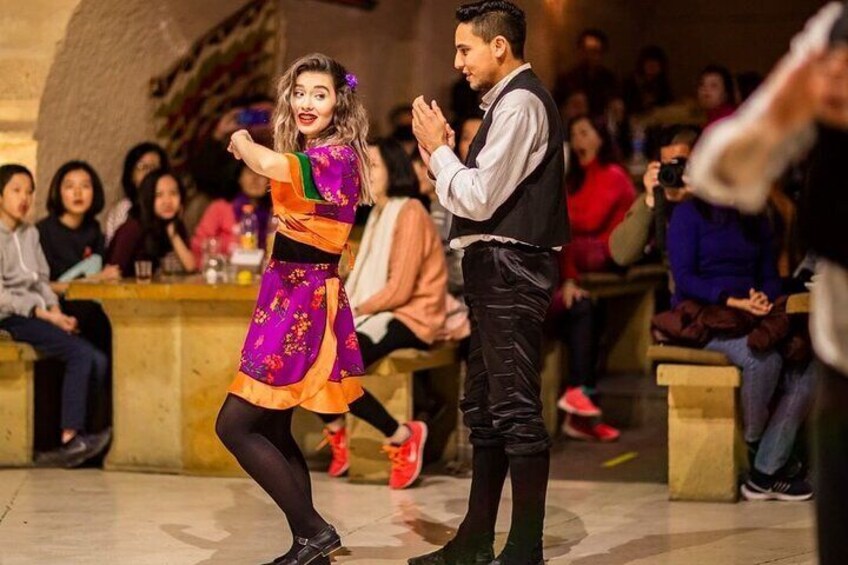 A person in a colorful traditional outfit dancing on stage. 2
