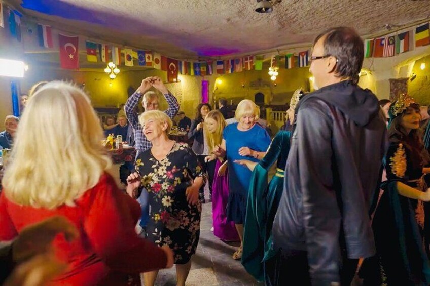 En gruppe mennesker danser i et rum med flag på væggene. 2