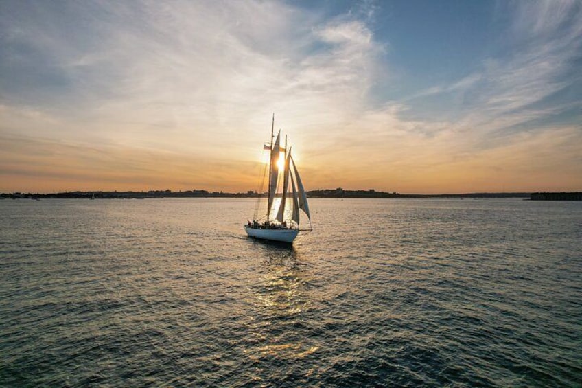 A sailboat on calm water during sunset. 2
