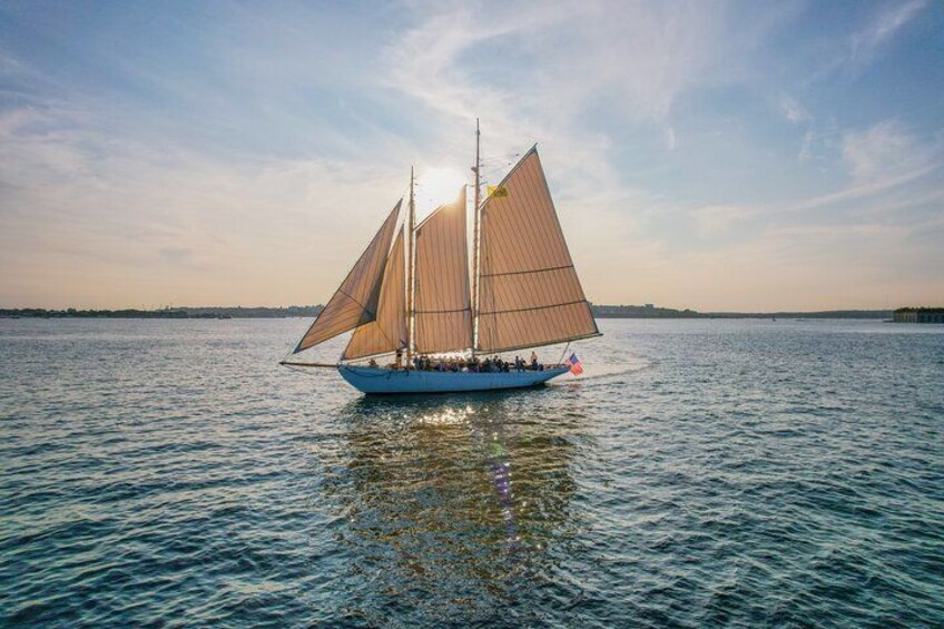 A sailboat with two masts and a crew on a calm body of water. 3