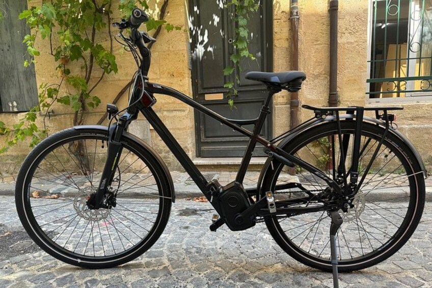 Una bicicleta negra estacionada en una calle adoquinada. 2