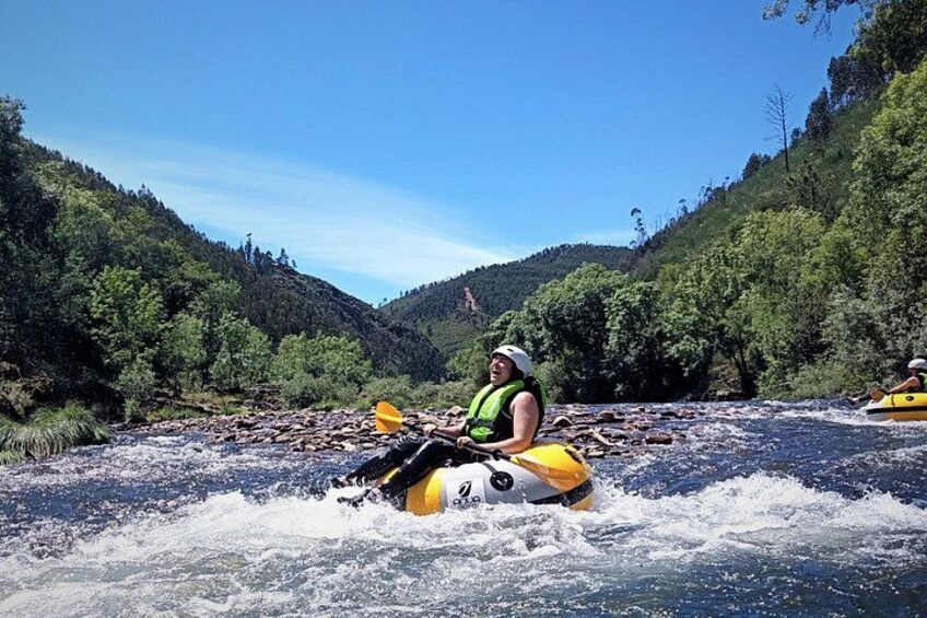 A person kayaking on a river surrounded by forested hills. 5