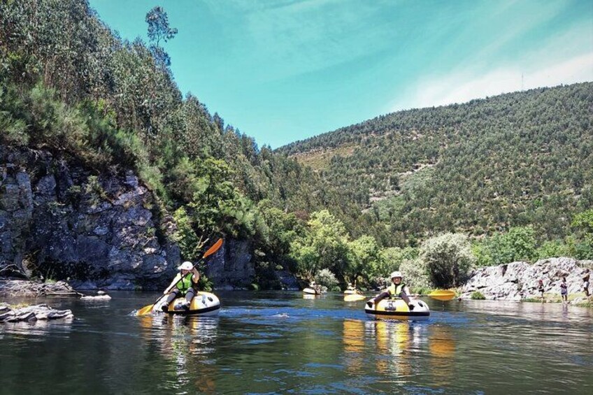 Dos kayakistas en un río tranquilo rodeado de colinas boscosas. 3