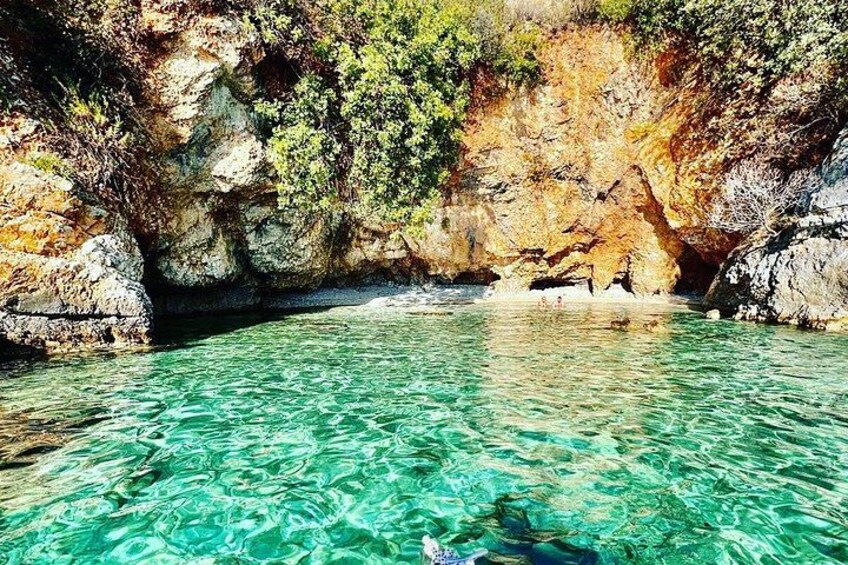 Une piscine d’un bleu turquoise éclatant, entourée de falaises rocheuses et d’une végétation clairsemée. 2