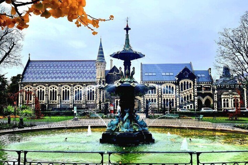 A historic building with ornate architecture, a fountain, and a clear sky. 3