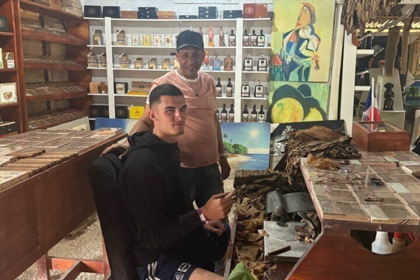 Una tienda de tabaco con estantes llenos de productos y una mesa con hojas de tabaco. 4