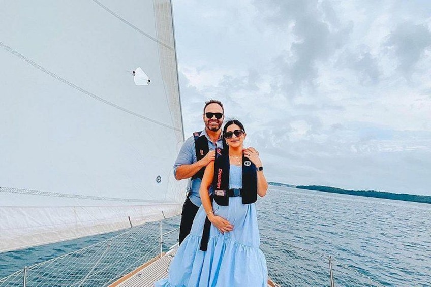 A sailboat with a person in a blue dress and another in a black vest. 3