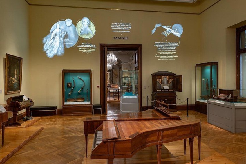 Een museuminterieur met houten meubels, een piano en wandmontages. 5