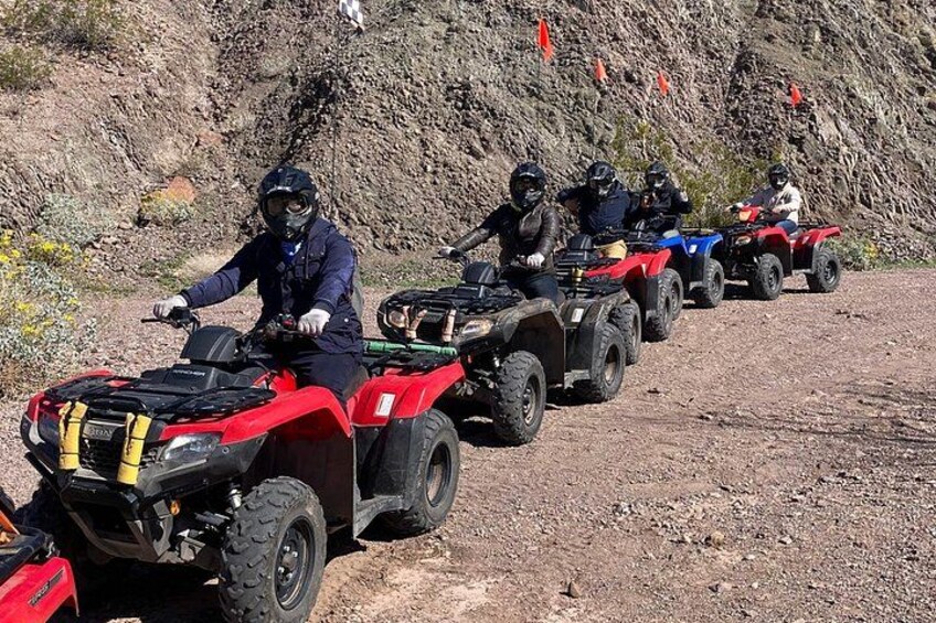Un grupo de personas en vehículos todo terreno circulando por un sendero de tierra con terreno rocoso y vegetación escasa. 4