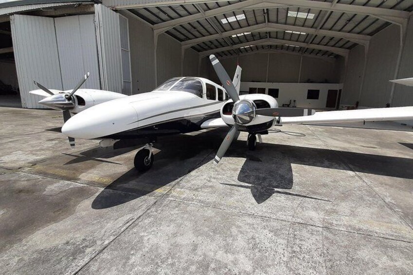 A small white airplane parked inside a hangar. 5