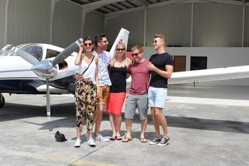 A group of people standing in front of an airplane on a tarmac. 3