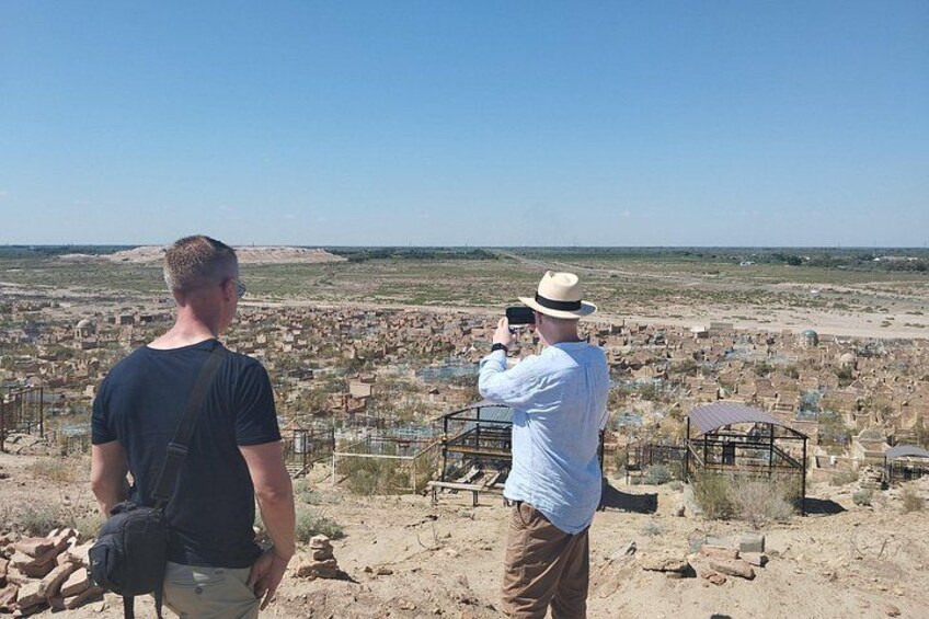 Deux personnes observent un site historique, avec ses ruines, sous un ciel dégagé. 5