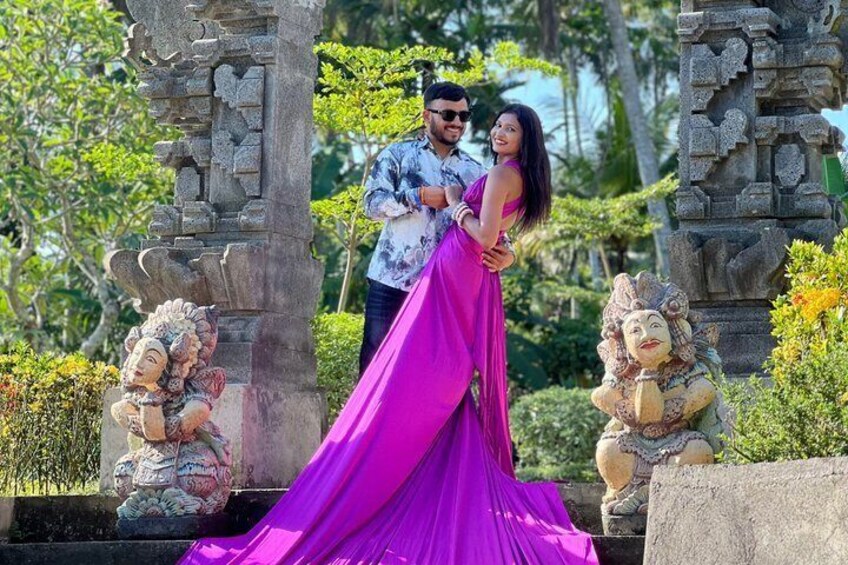 A couple in a garden with stone statues and a stone structure. 2
