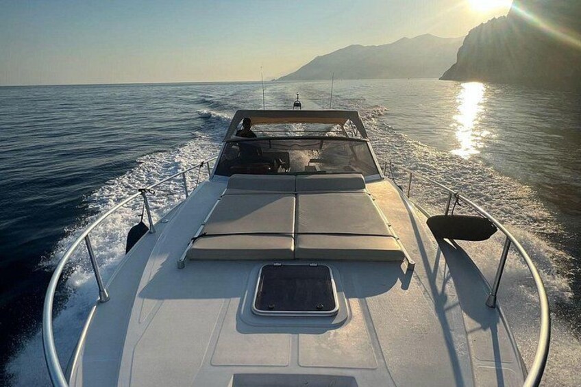 A boat on water with a sun setting in the background. 5