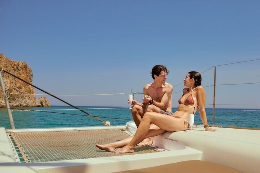 A couple on a boat near a rocky coastline. 1