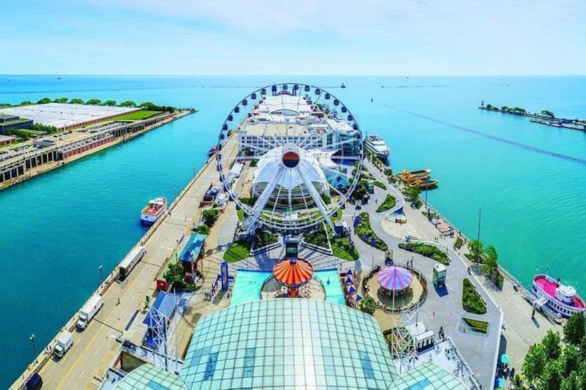 A large Ferris wheel, a waterfront promenade, and a modern building with a glass roof. 1