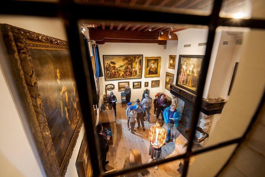 Una galería con pinturas en las paredes y gente observando. 4