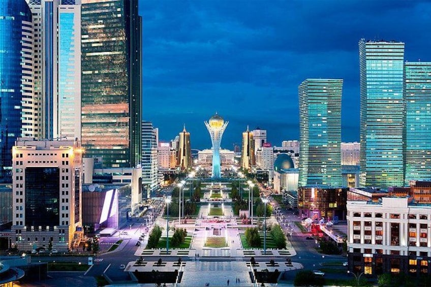 A cityscape at night with modern skyscrapers, a central plaza, and a distinctive building with a dome. 1