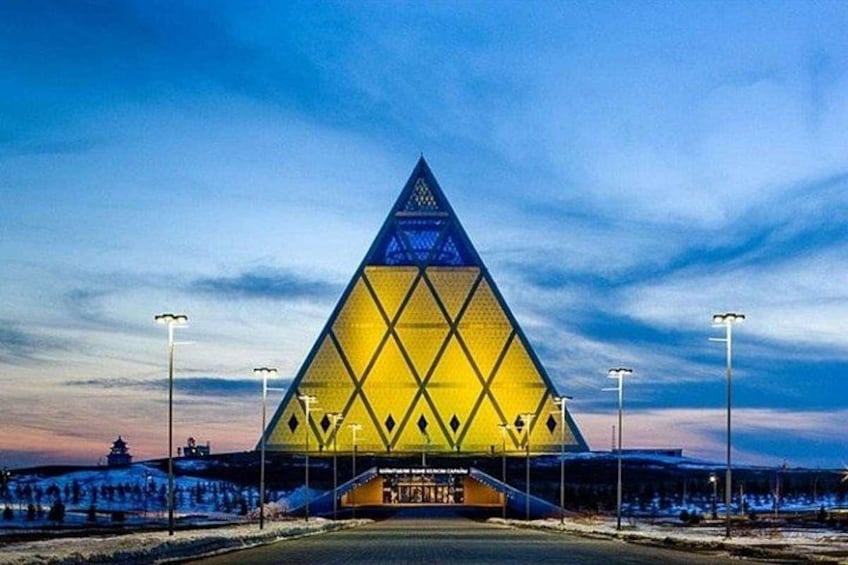 A large triangular building with a pyramid-like structure, surrounded by a snowy landscape and street lamps. 4