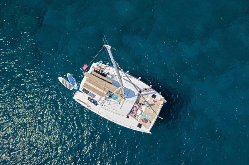 Un velero blanco con camarote, sillas de cubierta y una tabla de wakeboard sobre el agua. 5