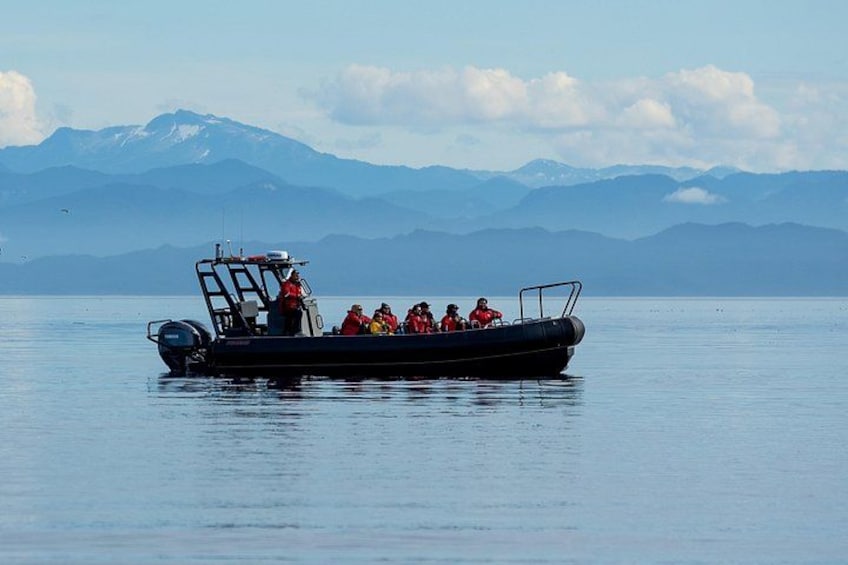 A boat with passengers on a calm lake with mountains in the background. 3