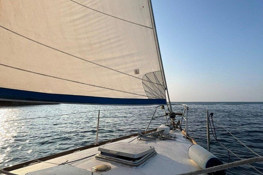 Een zeilboot met een groot zeil op een rustige zee. 3