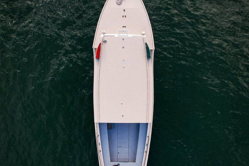 Un bateau blanc, doté d’un pont plat et d’un intérieur bleu, flotte sur une eau d’un vert foncé. 5