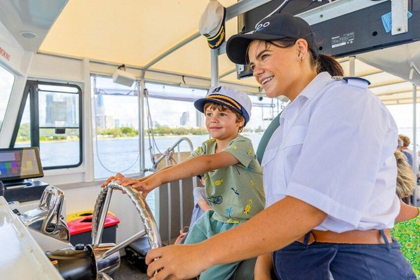 A person steering a boat, another person wearing a cap, and a child in a green shirt. 4