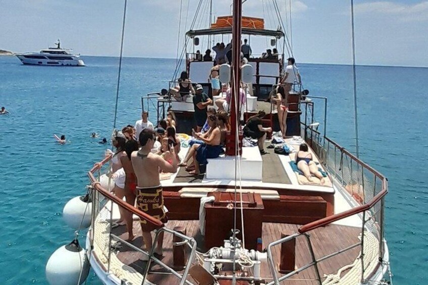 A boat with people sunbathing and swimming in the water. 2