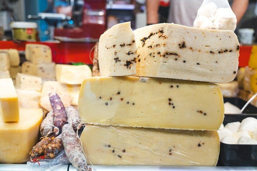 Variedad de quesos exhibidos en un puesto de mercado. 3