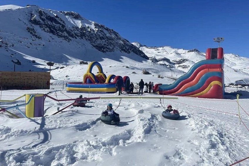Une zone montagneuse enneigée avec des toboggans gonflables et des bouées pour dévaler les pentes. 2