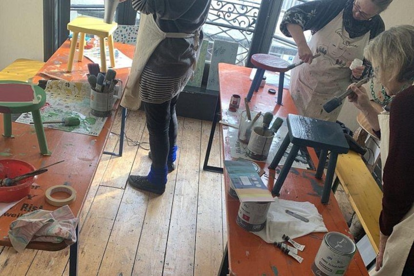 A workshop with people painting and using tools. 2